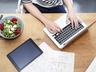 Arbeitsplatz mit Laptop, Tablet und gesundem Salat