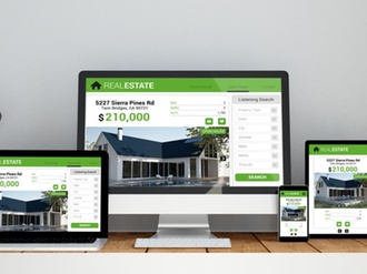 A computer, laptop, smartphone and tablet on a desktop workspace with real estate online responsive