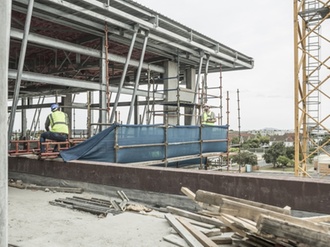 Baustelle Hochhaus mit zwei Bauarbeitern