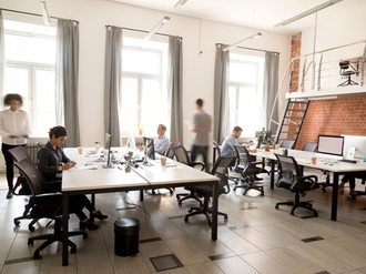 Corporate staff employees working together using computers at coworking, busy workers group walk in