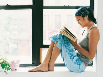 Frau liest ein Buch am Fenster