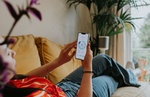 Frau Sofa Heizen Smartphone Temperatur Wohnzimmer