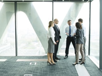 Geschäftsleute besprechen sich fröhlich in hellem Büro