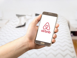Hand mit Airbnb auf Smartphone