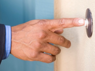 Hand mit Türklingel