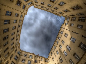 Innenhof Berliner Mehrfamilienhäuser Blick in Himmel bewölkt