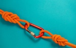 Red carbine with clutch. Equipment for climbing and mountaineering. Safety rope. Knot eight.