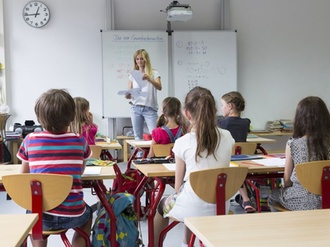 Klassenraum mit Lehrer und Kindern in der Grundschule