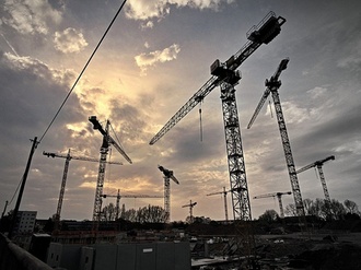 Kräne auf Baustelle in Abendstimmung