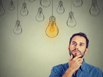 Portrait thinking handsome man looking up with idea light bulb above head isolated on gray wall back