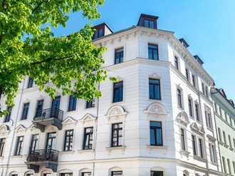 Mehrfamilienhaus Altbau weiß blauer Himmel