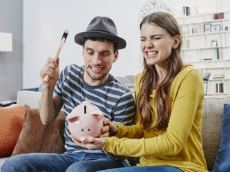 Couple in furniture store demolishing piggy bank