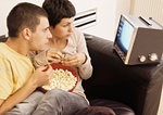 Paar zuhause, mit Popcorn beim Fernsehen