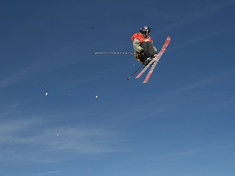 Skifahrer_Ski-Akrobat vor blauem Himmel in der Luft