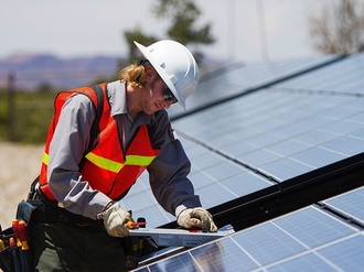 Solaranlage_ Arbeiter baut Solarzellen auf Dach