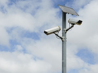 A solar powered surveillance camera on a pole.