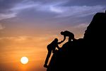 Silhouette of helping hand between two climber