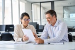 Young Asian account manager advisor lawyer showing paper documents to Latin client partner, diverse