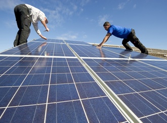 Zwei Männer installieren Solarzellen auf einem Dach